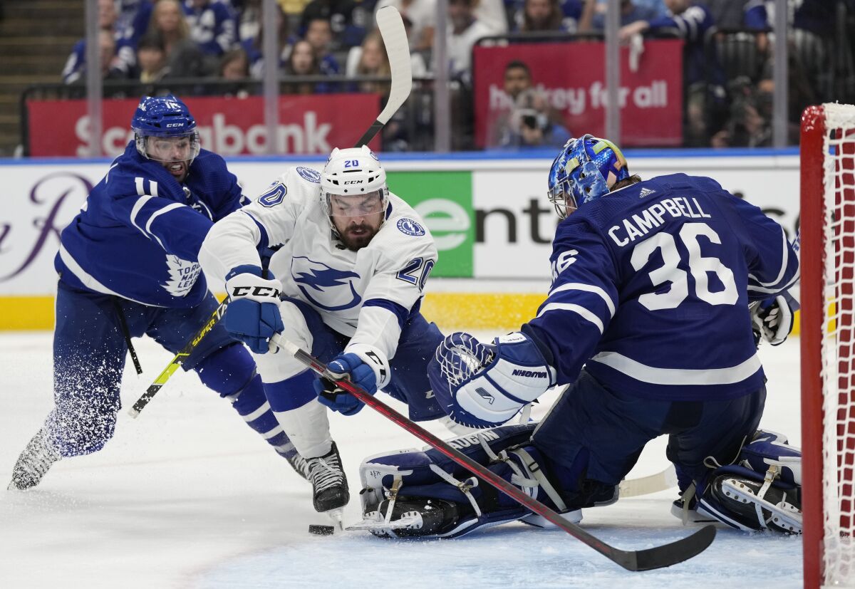 Tampa Bay's Nicholas Paul (20) falls toward Toronto goalie Jack Campbell (36) as center Colin Blackwell (11) defends.
