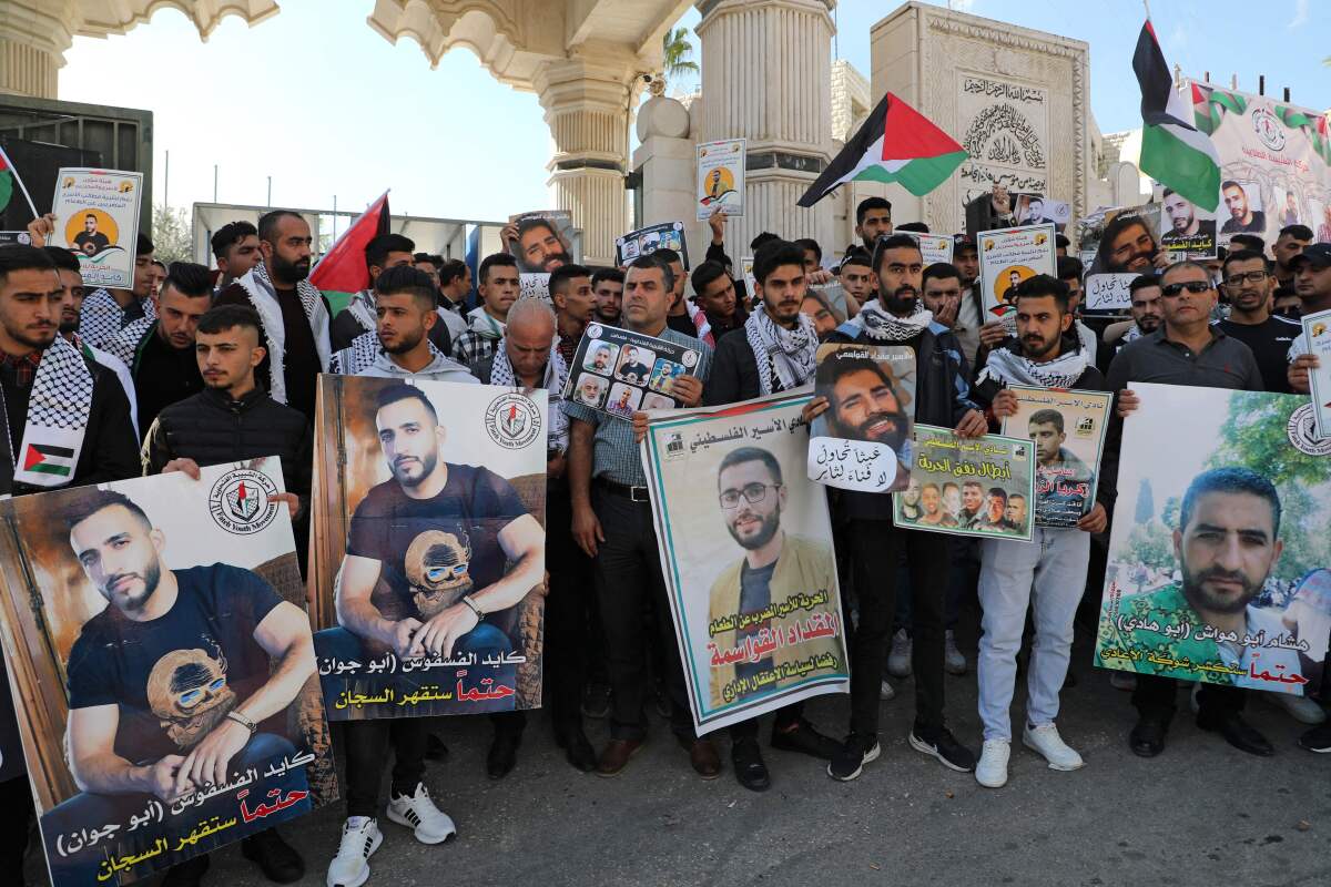 Palestinians gather with banners calling for the release of Palestinian prisoners on hunger strike in Israeli jails