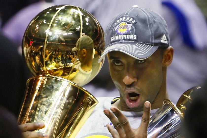 Lakers guard Kobe Bryant holds the Larry O'Brien Trophy while celebrating his fourth championship with the team following a win over the Orlando Magic in Game 5 of the 2009 NBA Finals.