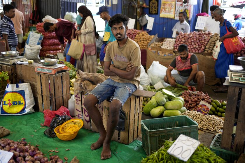 A vendor waits for customers at a market place in Colombo, Sri Lanka, Thursday, June. 1, 2023. The Central Bank of Sri Lanka reduced its interest rates Thursday, June 1, 2023, for the first time since the island nation declared bankruptcy last year. Stern fiscal controls, improved foreign currency income and help from an International Monetary Fund program has resulted in inflation slowing faster than expected. (AP Photo/Eranga Jayawardena)