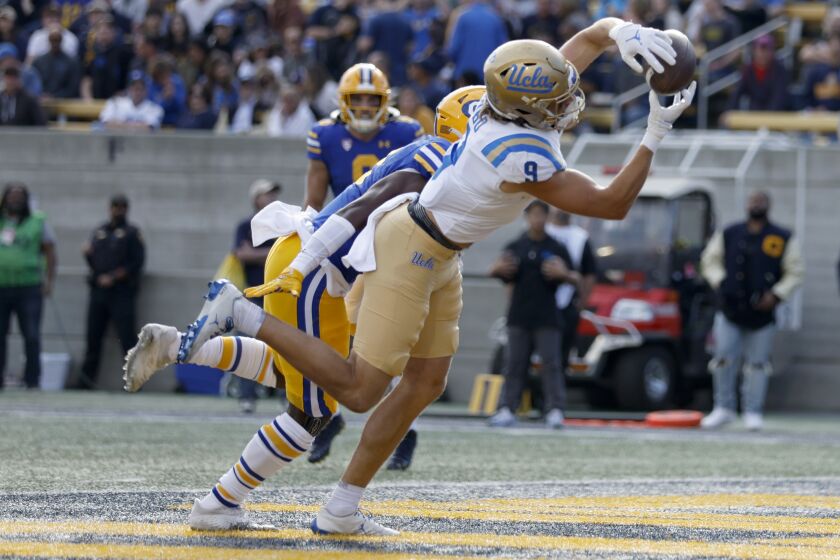 UCLA wide receiver Jake Bobo (9) catches a touchdown in front of California safety Craig Woodson (2) during the first half of an NCAA college football game in Berkeley, Calif., Friday, Nov. 25, 2022. (AP Photo/Jed Jacobsohn)