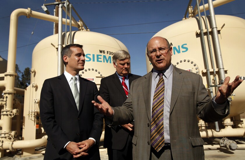 L.A. Mayor Eric Garcetti, left, and the DWP's head of operations, Marty Adams, right, discuss the city's response to the drought at the Tujunga Spreading Grounds in Arleta in 2014. Garcetti signed new water-saving measures this week.