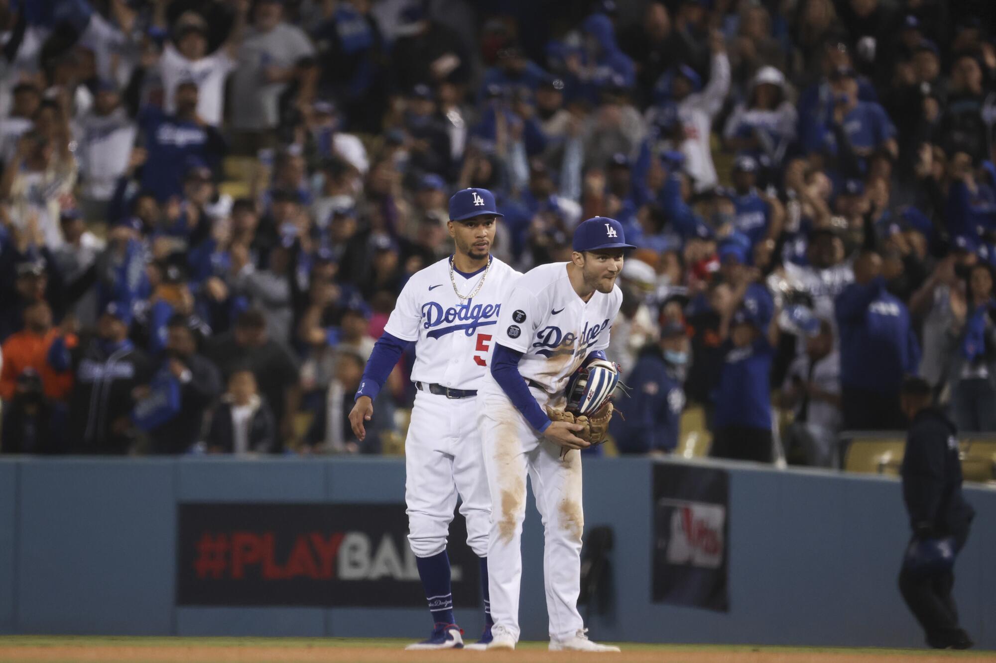 Los Angeles Dodgers second baseman Trea Turner, front, reacts after nearly colliding with right fielder Mookie Betts