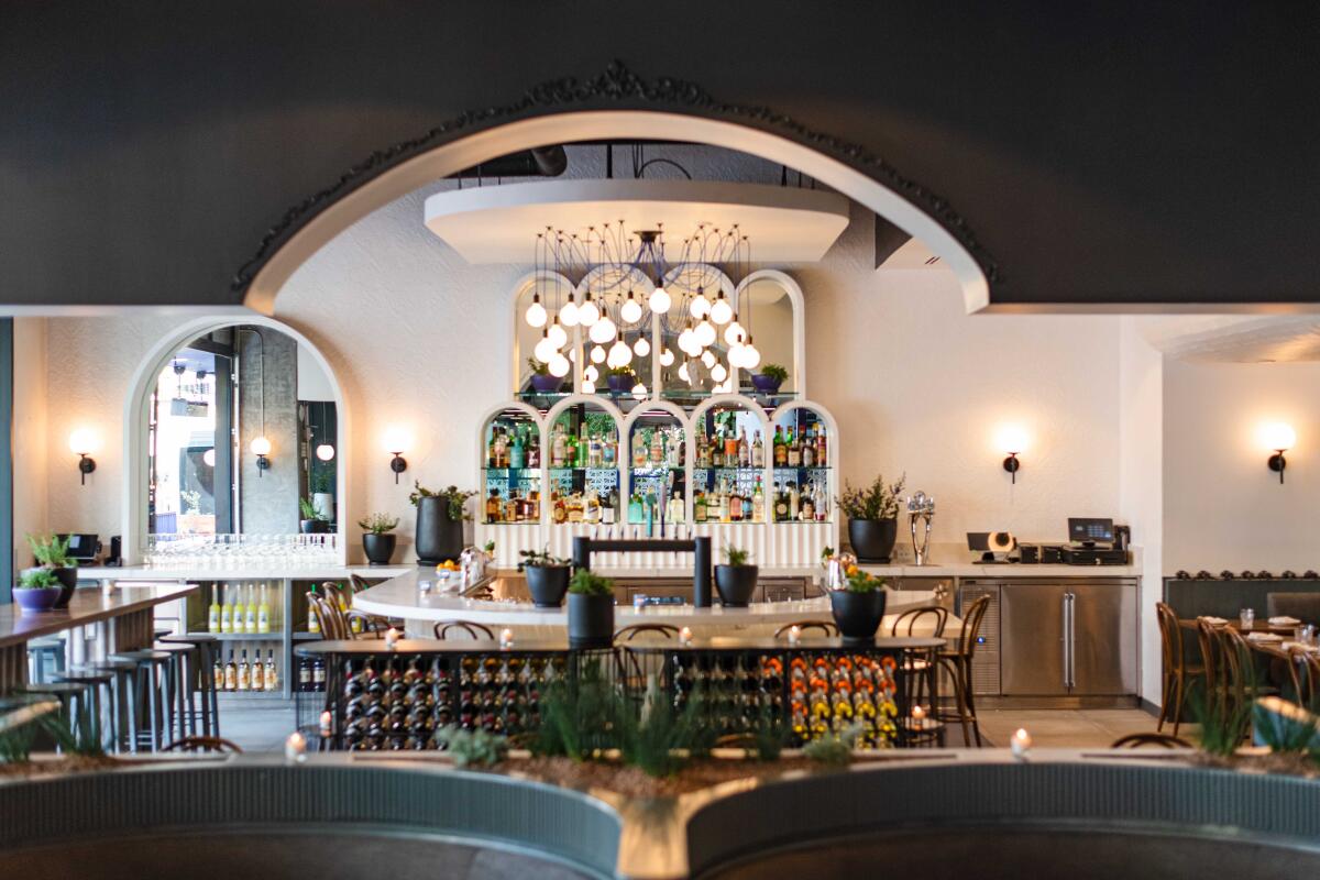 interior of a restaurant with arched shelves holding bottles of liquor