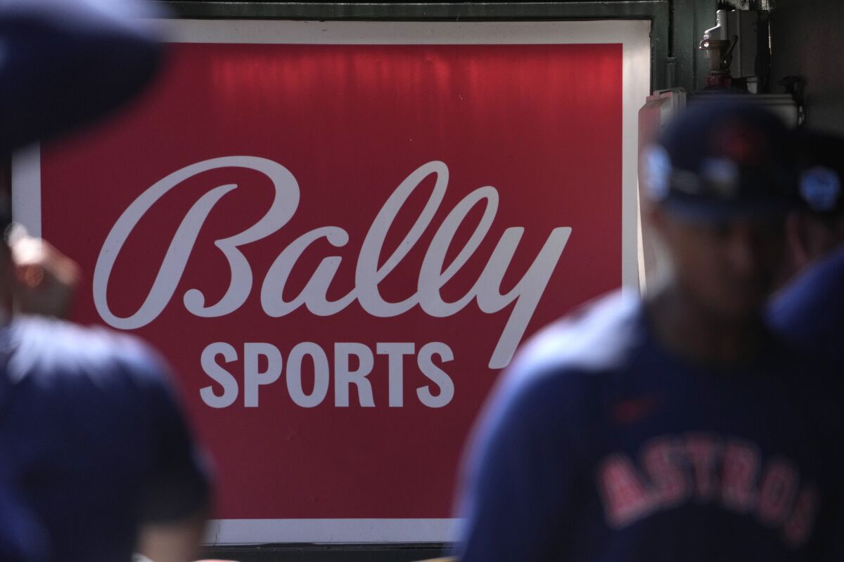 Houston Astros oyuncuları sığınakta bir Bally Sports tabelasının önünde yürüyor.