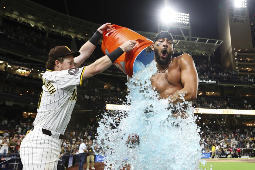 Jake Cronenworth vacía la hielera encima del dominicano Fernando Tatis, su compañero en los Padres de San Diego, quien conectó el hit de la victoria sobre los Tigres de Detroit en la décima entrada del juego del miércoles 4 de septiembre de 2024 (AP Foto/Derrick Tuskan)