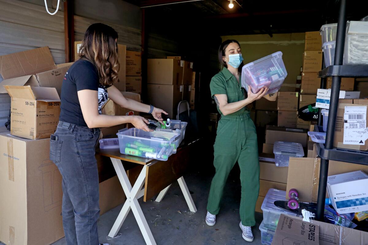 Sofia Laguna and Carol Newark, gather hygiene supplies at Harm Reduction Institute's storage facility in Santa Ana.