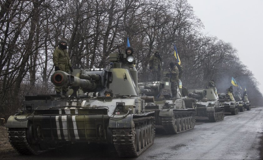 Ukrainian soldiers ride atop armored vehicles on the outskirts of Donetsk on March 4 as heavy weapons are pulled back under terms of a cease-fire reached on Feb. 12.