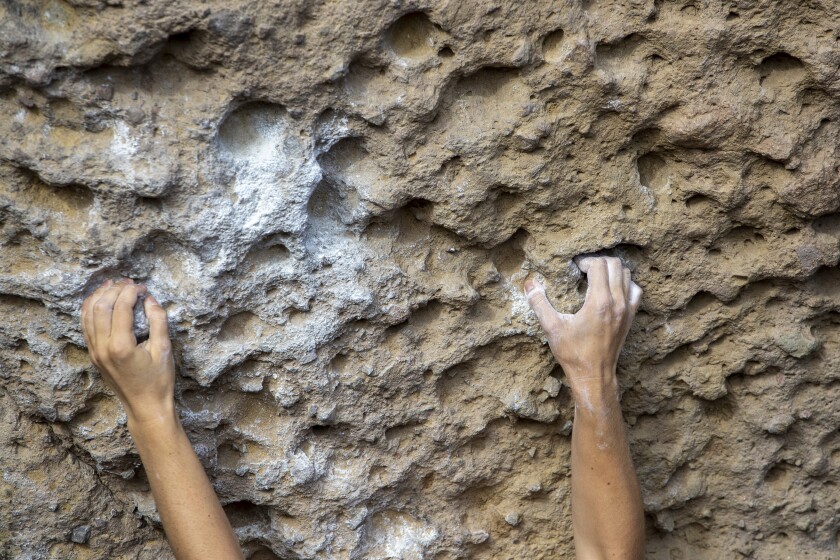 Las manos calcadas encuentran asideros en las rocas del parque estatal Malibu Creek.