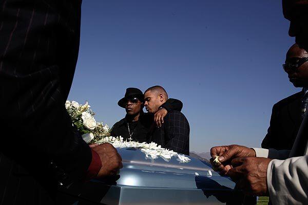 Anthony Blanks, center right, is comforted by a friend during burial services for his brother, well-known Los Angeles gang interventionist Ronald "Looney" Barron, at Forest Lawn Hollywood Hills.