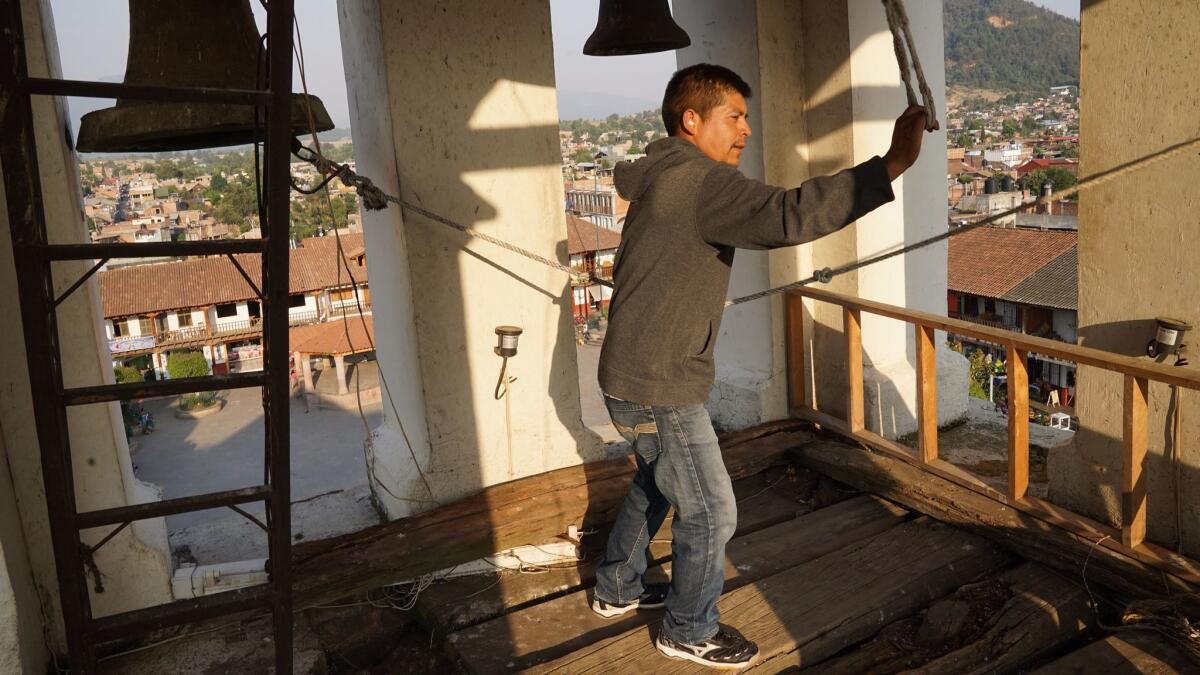 Al igual que en el inicio de la rebelión de Cherán, el 15 de abril de 2011, un hombre hace sonar las campanas de la iglesia, en una torre elevada de la ciudad (Liliana Nieto del Río / para The Times).