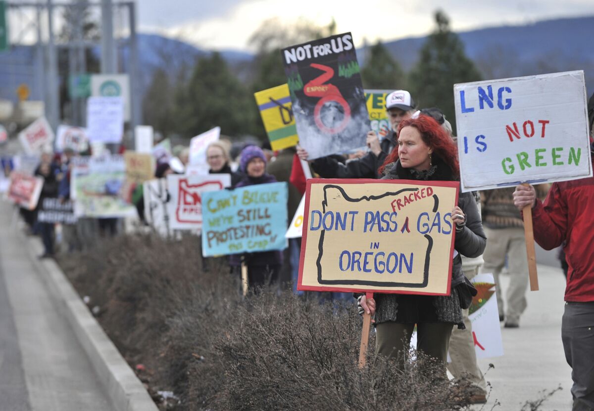 FILE - People protest against the Jordan Cove LNG Pipeline on Crater Lake Highway in Medford, Ore., on Jan. 6, 2016. The company that sought to build the natural gas pipeline and marine export terminal in Oregon pulled the plug on the controversial project Wednesday, Dec. 1, 2021, after failing to obtain all necessary state permits. (Jamie Lusch/The Medford Mail Tribune via AP, File)