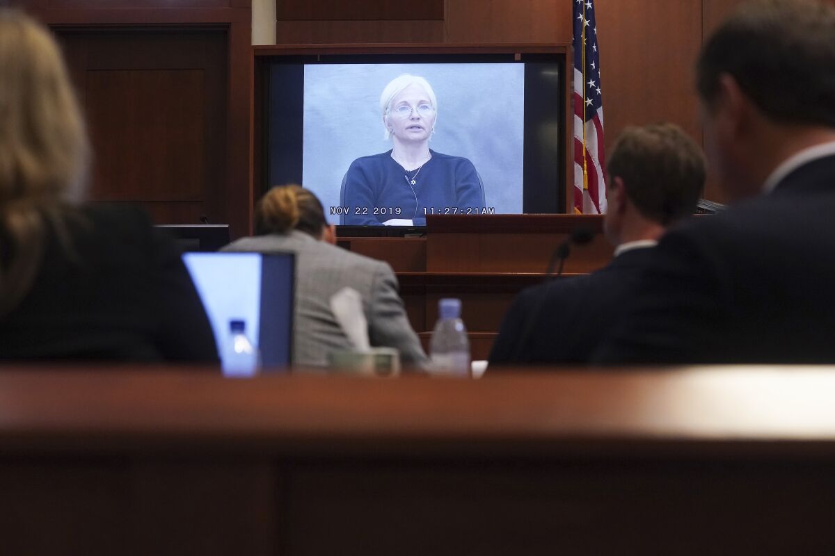 A woman is seen on a video screen displayed in court