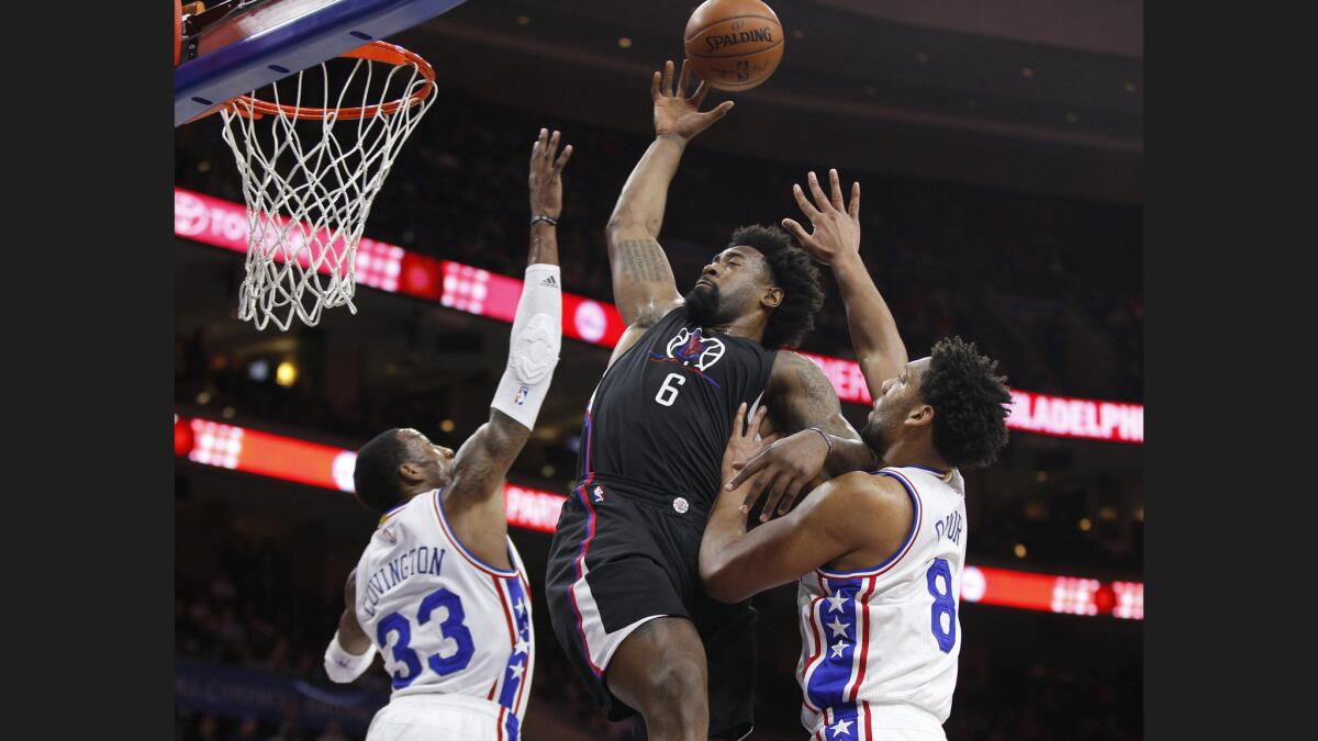 Clippers center DeAndre Jordan (6) goes up to shoot between 76ers forwards Robert Covington (33) and Jahlil Okafor (8) during the first half.