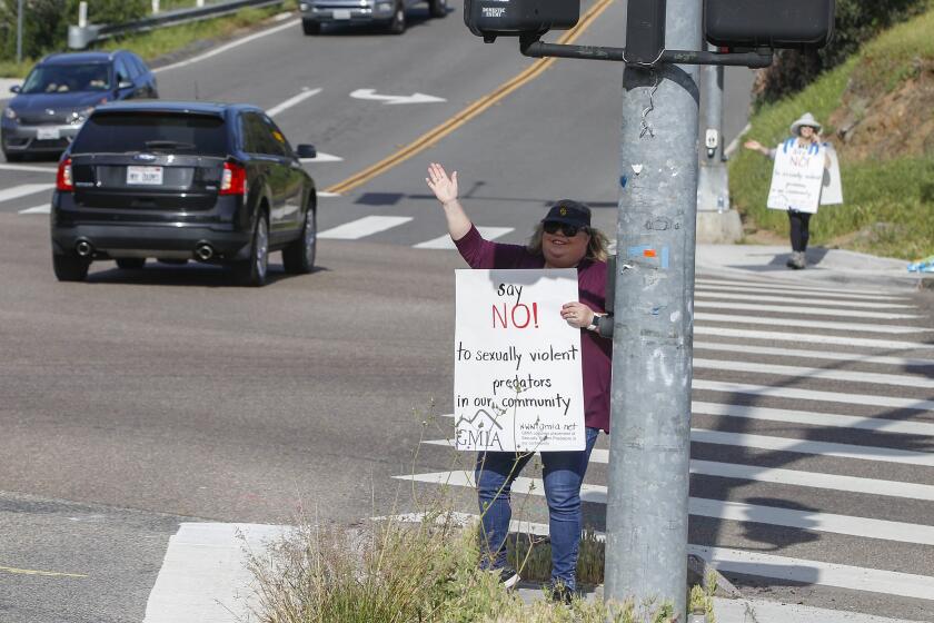 LA MESA, CA - APRIL 06: Kathleen Hedberg, president of the Grossmont Mount Helix Improvement Association, carries a sign against the proposed placement of sexually violent predator Douglas Badger while protesting at the corner of Avocado Blvd. and Fuerte Drive on Tuesday, April 6, 2021 in La Mesa, CA. (Eduardo Contreras / The San Diego Union-Tribune)