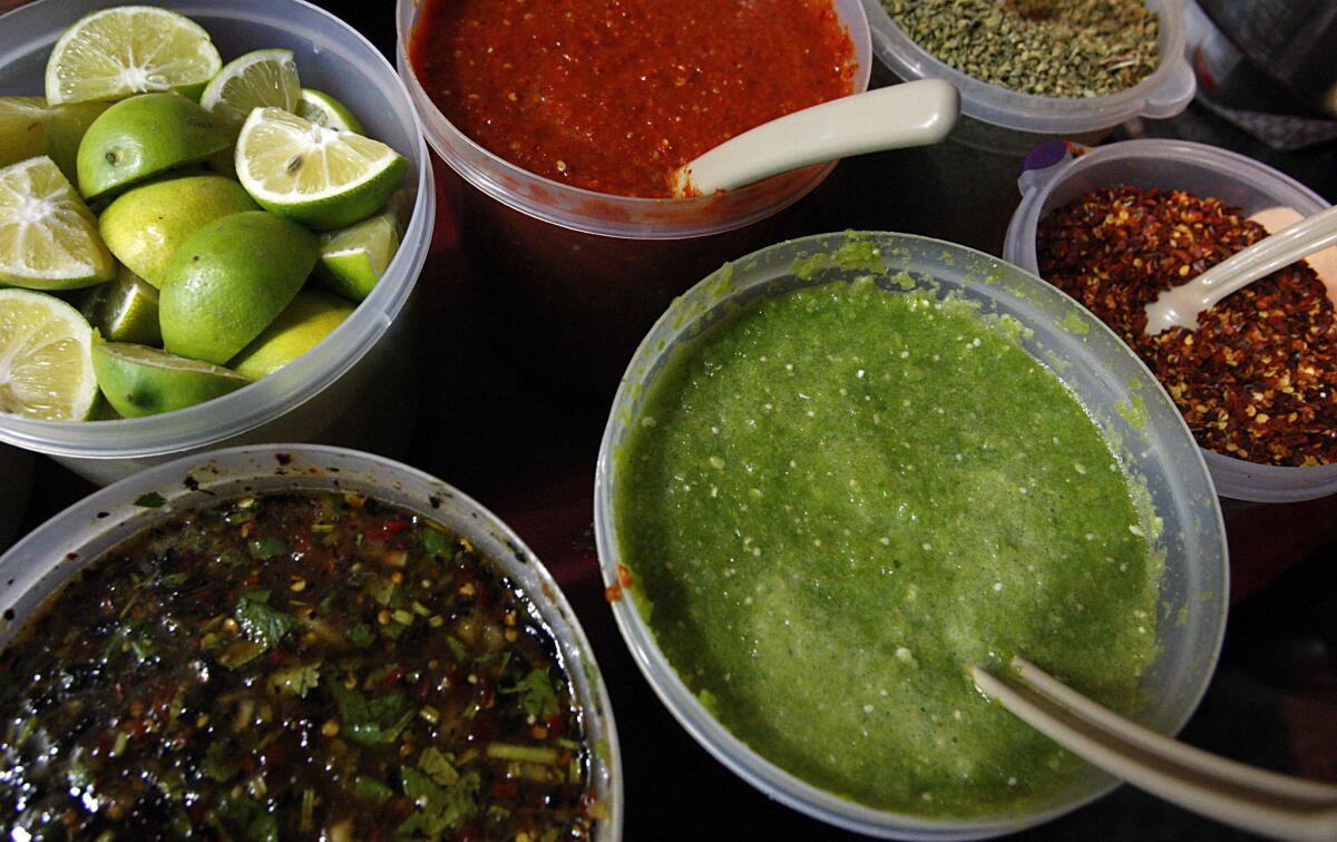 Salsas and spices are part of a sidewalk food stall in Boyle Heights.