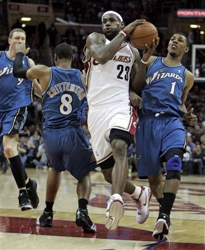Cleveland Cavaliers' LeBron James (23) squeezes past Washington Wizards' Javaris Crittenton (8) and Nick Young (1) in the first quarter in an NBA basketball game, Wednesday, April 8, 2009, in Cleveland. Darius Songaila (9), of Lithuania, watches. (AP Photo/Tony Dejak)