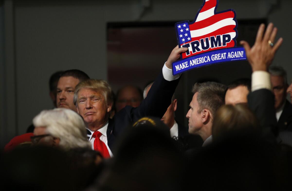 Republican presidential candidate Donald Trump holds one of his signs after a rally in Mount Pleasant, S.C.