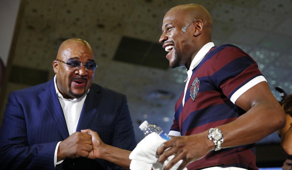 Floyd Mayweather Jr., right, shakes hands with Leonard Ellerbe during a grand arrival for Mayweather's upcoming fight on Tuesday.