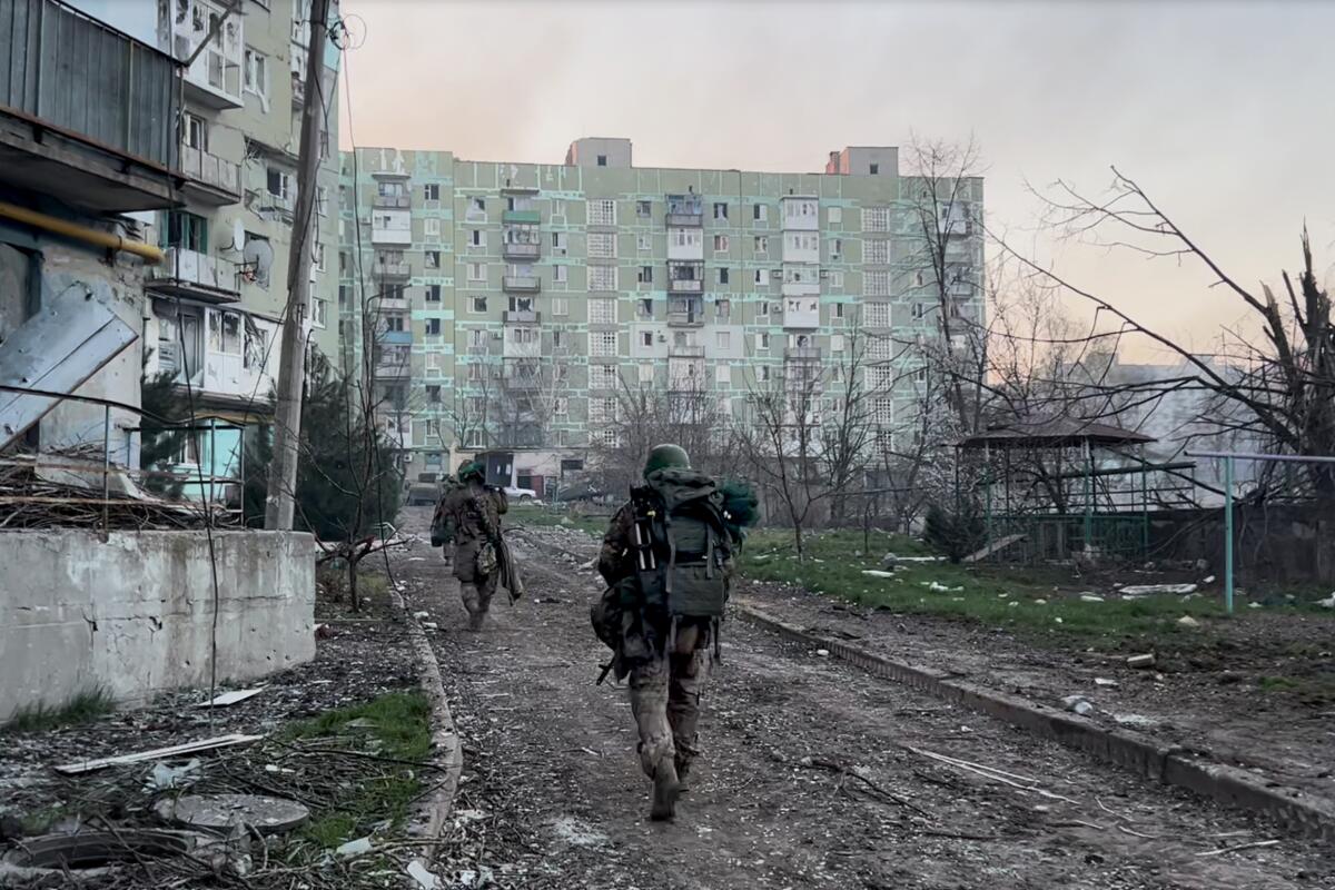 Ukrainian soldiers walk in a deserted city 