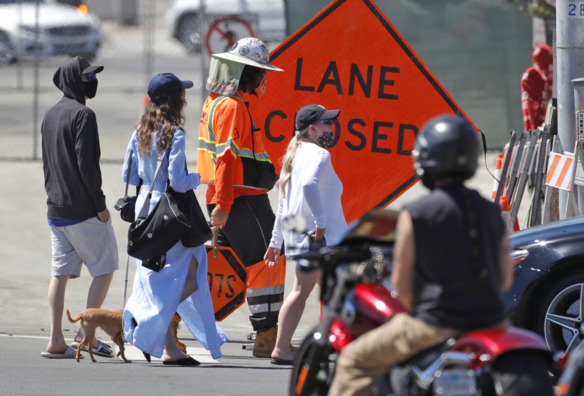 Pedestrians and traffic cross the street at Ocean Avenue near the Laguna box culvert construction project.