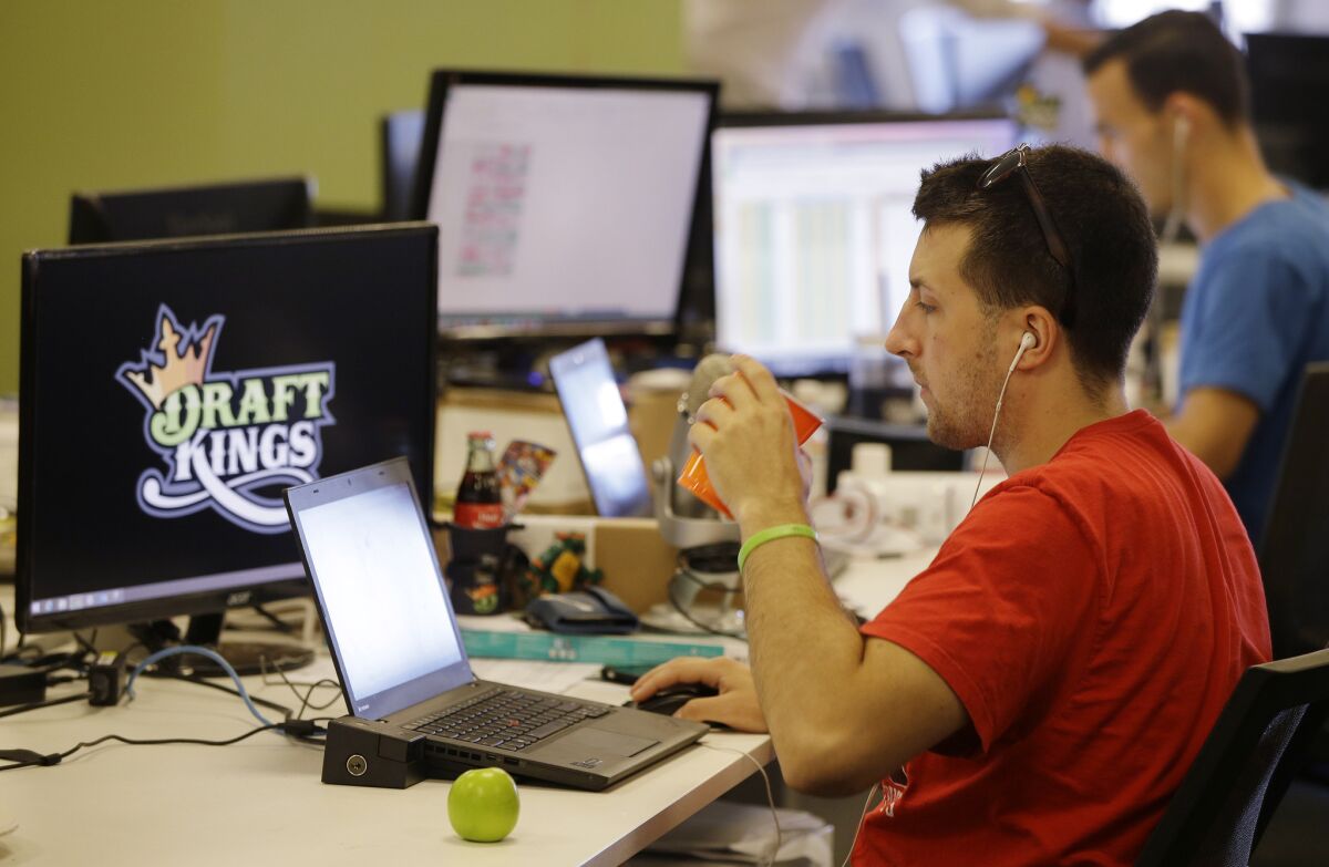 A news manager works on his laptop at the Boston office of daily fantasy sports company DraftKings. Last week, the company went public in a $3.3-billion reverse merger with a SPAC.
