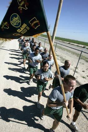 Joe Sorrento carries the class flag during a two-mile conditioning run around the perimeter of the academy. The 24-year-old former bartender from Buffalo, N.Y., will be assigned to the border south of Tucson.