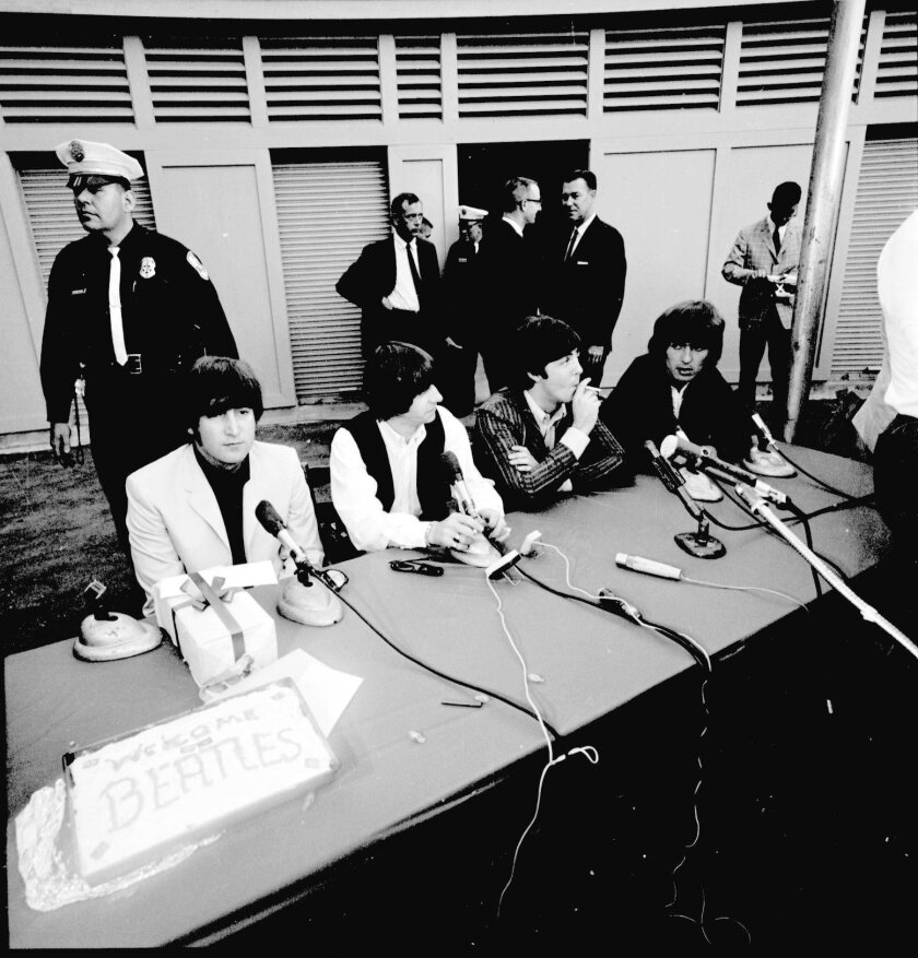 The Beatles are shown at a backstage press conference in 1965 at Balboa Stadium, prior to the iconic English rock band's only San Diego performance.
