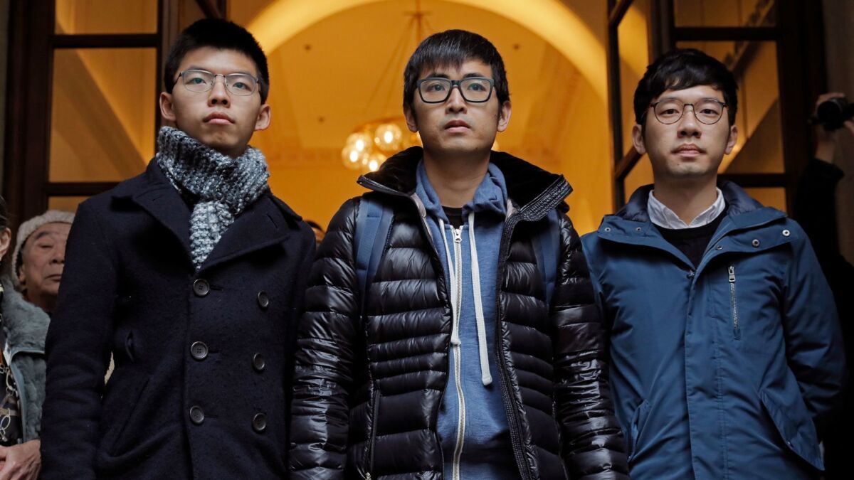 Pro-democracy activists, from left, Joshua Wong, Alex Chow and Nathan Law, walk out from the Court of Final Appeal in Hong Kong on Tuesday, Feb. 6, 2018. Hong Kong's highest court overturned prison sentences for the three young pro-democracy activists.