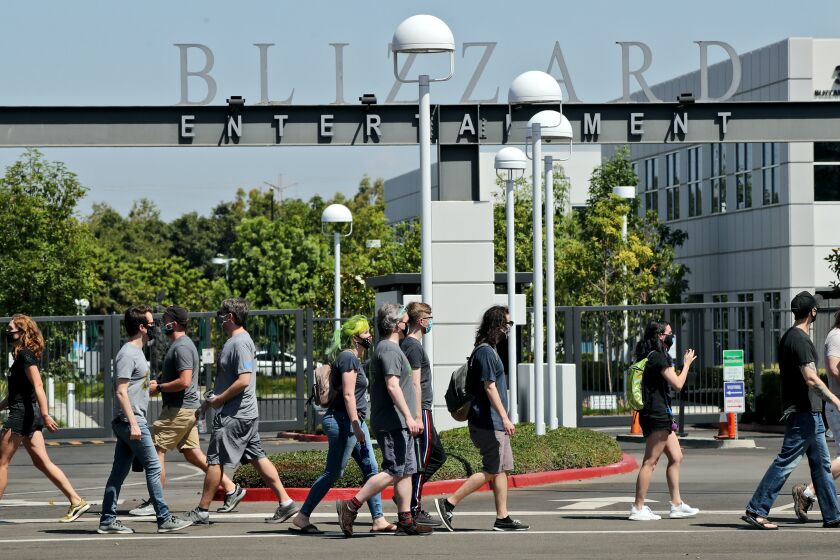 Employees pass in front of the main entrance during walkout to protest the reported sexual harassment and discrimination at Activision Blizzard, in Irvine on Wednesday, July 28, 2021. An organizer who did not want to give her name said that the walkout was "in solidarity with the victims who have stood up, who have made their voices heard. And we are looking to amplify those voices as well as to create a call to action on the demands that we listed." The company statement sent via email to this reporter by employee Christy Um said OWe are fully committed to fostering a safe, inclusive and rewarding environment for all of our employees around the world. We support their right to express their opinions and concerns in a safe and respectful manner, without fear of retaliation. The company does not retaliate for any such decision, should employees choose to participate or not. The company will not require employees to take time off to participate in this walkout.O The walkout began at 10am and continued until 2 pm. Nofurther actions were planned, according to walkout representatives.