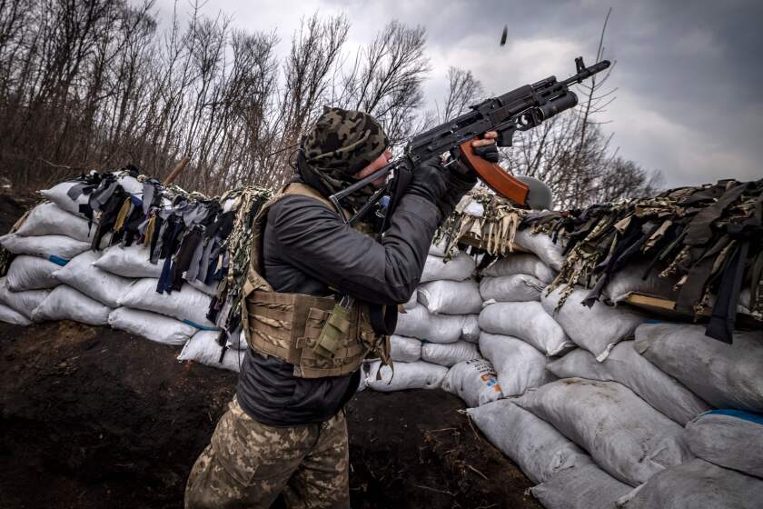 A Ukrainian serviceman shoots with an assault rifle from a trench at the front line east of Kharkiv on March 31, 2022. - Russian forces are repositioning in Ukraine to strengthen their offensive on the Donbass, Nato said on March 31, 2022, on the 36th day of the Russian-Ukrainian conflict, as shelling continues in Kharkiv (north) and Mariupol (south). (Photo by FADEL SENNA / AFP) (Photo by FADEL SENNA/AFP via Getty Images)