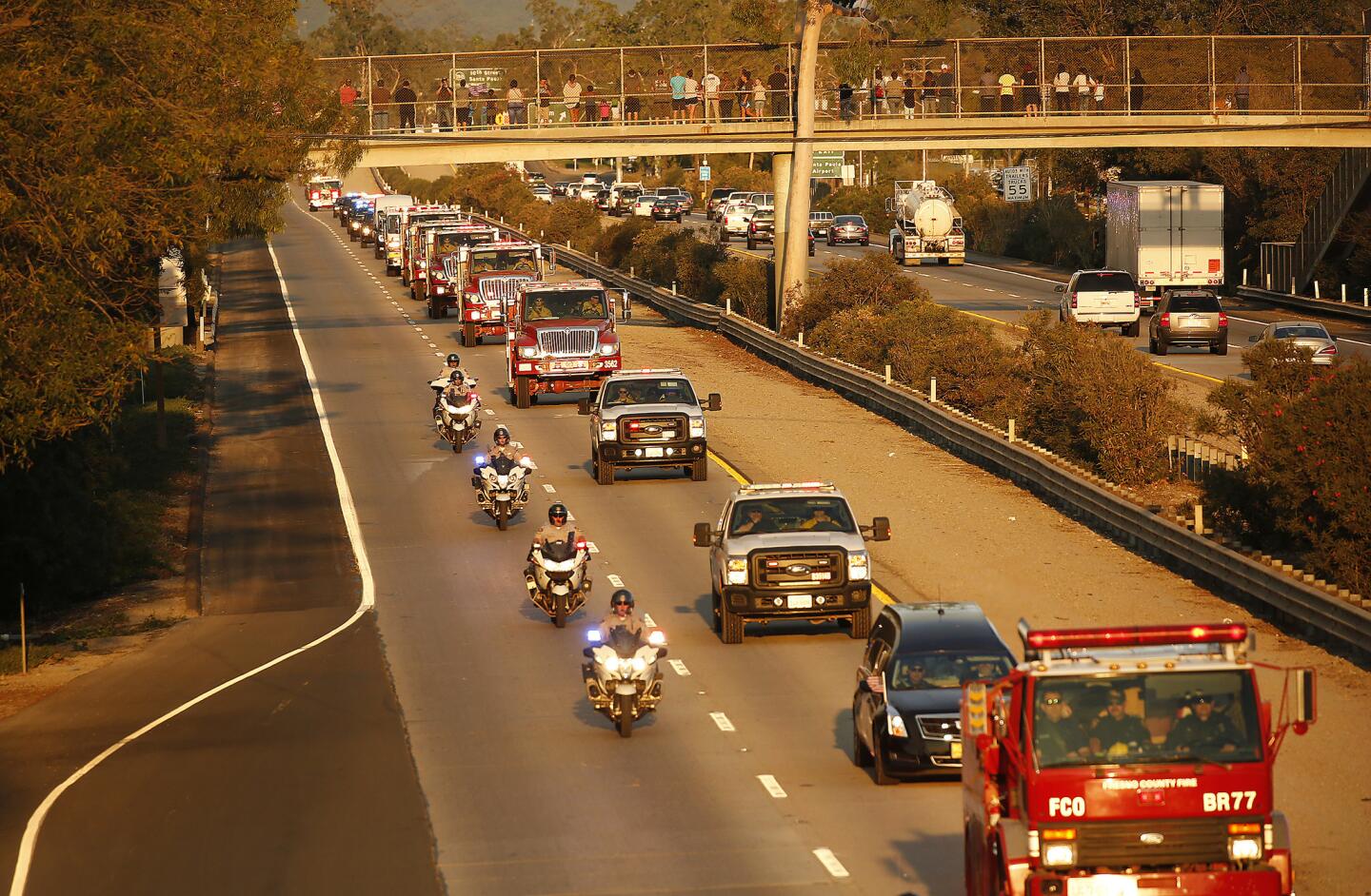 A motorcade proceeds down Highway 126 in Santa Paula carrying the body of firefighter Cory Iverson, 32, who died Thursday morning while battling the Thomas fire outside Fillmore.