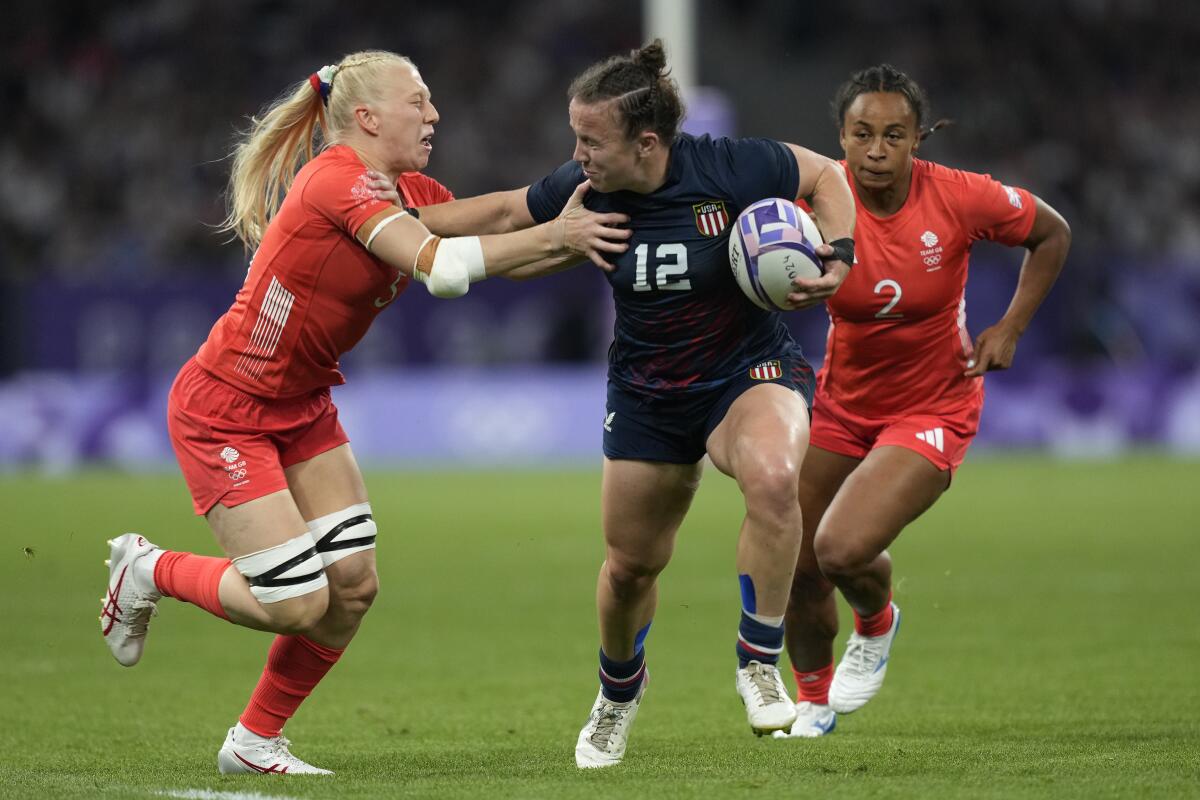 Kristi Kirshe of the U.S. fends off Great Britain's Ellie Boatman, left, during a women's quarterfinal rugby sevens match.