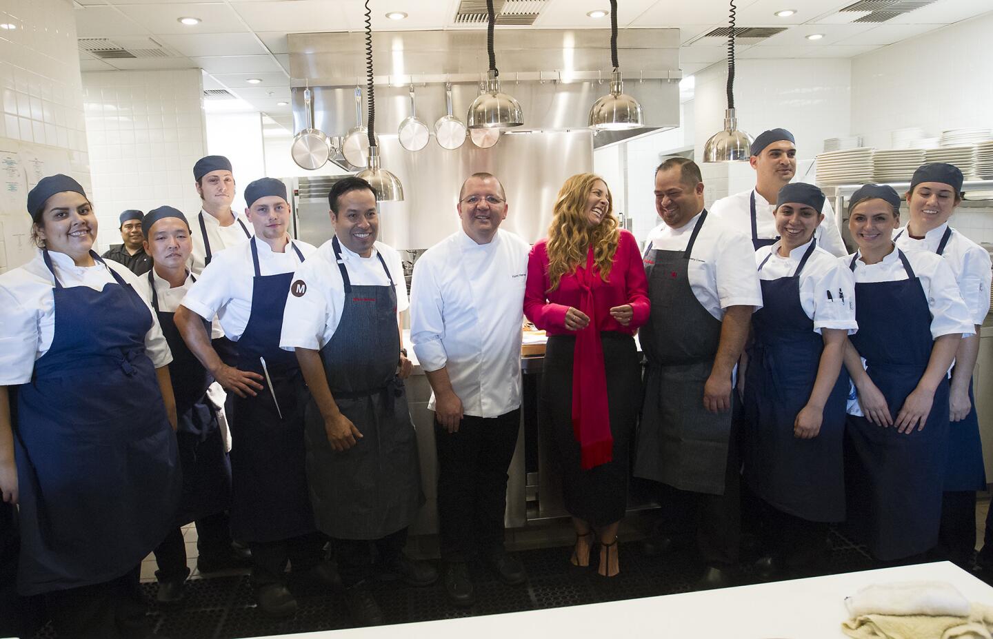 The kitchen staff stands with chefs and owners Florent and Amelia Marneau, center, during the grand opening preview of Marché Moderne restaurant in Crystal Cove Shopping Center in Newport Beach.