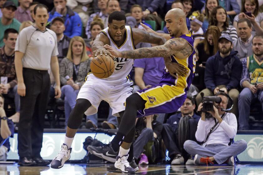 Lakers center Robert Sacre guards Jazz forward Derrick Favors during the second quarter of a game Wednesday in Utah.