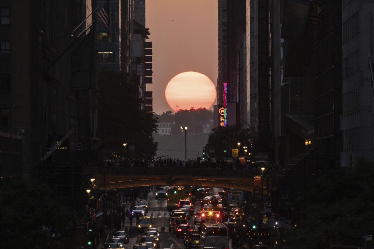 ARCHIVO - El Sol se oculta entre los edificios de 42nd Street en Nueva York 