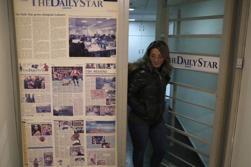 FILE - An employee of The Daily Star newspaper opens the main door of the newspaper office, in Beirut, Lebanon, Tuesday, Feb. 4, 2020. Lebanon's Daily Star newspaper, one of the leading English-language newspapers in the Arab world and Lebanon's oldest, has folded following a years-long financial struggle. Employees were formally informed of the decision to lay off all staff as of October 31 in an email sent to staff earlier this week and seen by The Associated Press Tuesday, Nov. 2, 2021. (AP Photo/Hussein Malla)