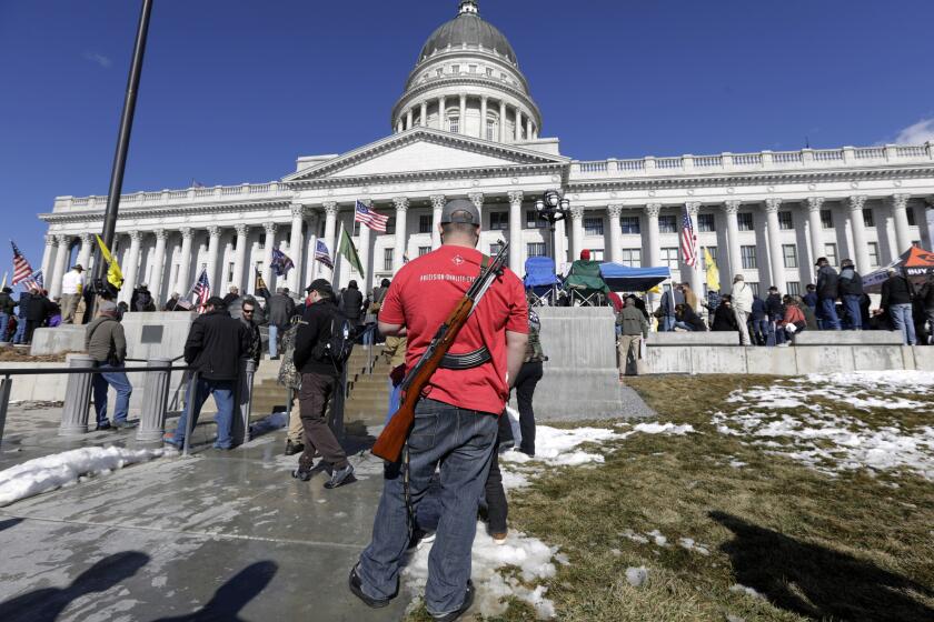 FILE - A man carries his weapon during a second amendment gun rally at Utah State Capitol on Feb. 8, 2020, in Salt Lake City. Utah is one of several more states weighing proposals this year that would allow people to carry concealed guns without having to get a permit, a trend supporters say bolsters Second Amendment rights but is alarming to gun-control advocates. (AP Photo/Rick Bowmer, File)
