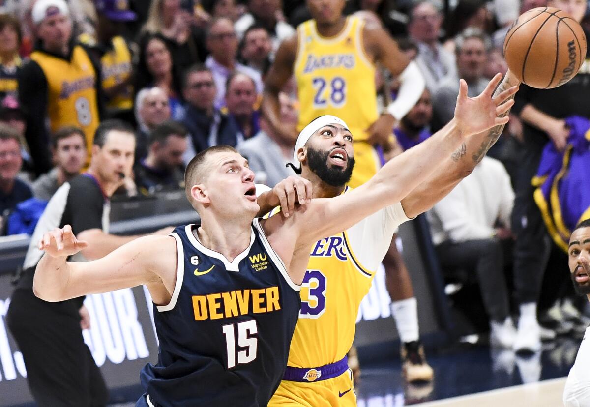 Nuggets center Nikola Jokic, left, and Lakers forward Anthony Davis reach out for a rebound.