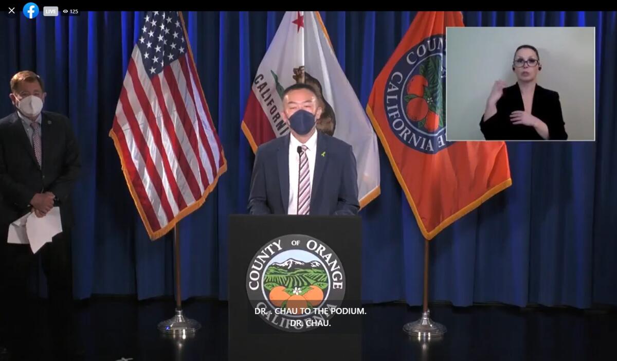 Orange County Health Agency Director Dr. Clayton Chau stands behind a lector. 