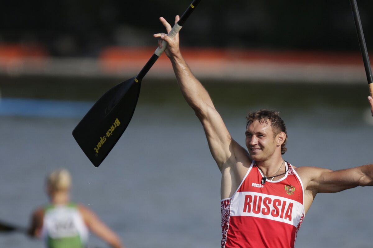 FILE - Winner Nikolay Lipkin celebrate after winning the C1 relay men 200m final of the ICF Canoe Sprint World Championships 2014 with teammate Andrey Kraitor, in Moscow, Russia, Sunday, Aug. 10, 2014. Three Russian canoeists including a gold medalist at the 2012 London Olympics have been banned or being part of the state-backed doping program eight years ago. The Court of Arbitration for Sport said its judges upheld appeals filed by the World Anti-Doping Agency (WADA) after the International Canoe Federation refused to prosecute individual cases. (AP Photo/Pavel Golovkin, File)