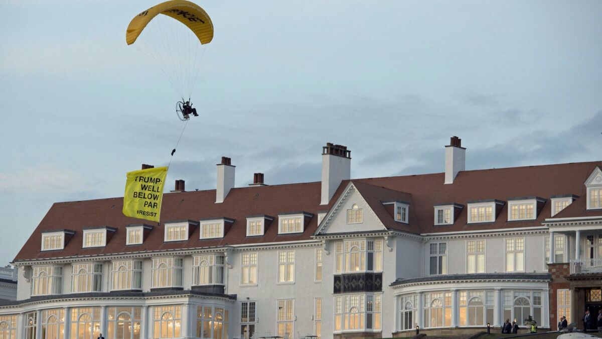 A Greenpeace protester flying a microlight passes over President Trump's resort in Turnberry, Scotland, on July 13, 2018, with a banner reading "Trump: Well Below Par."