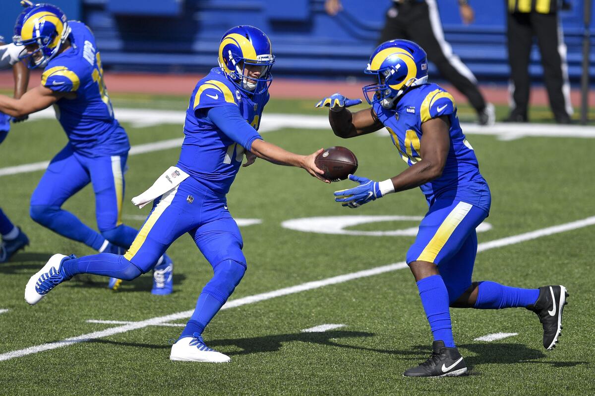 Rams quarterback Jared Goff hands the ball to running back Malcolm Brown.