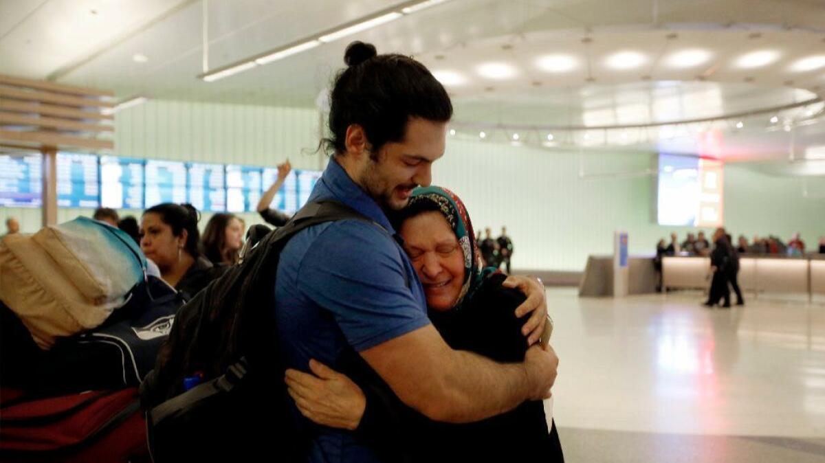 Siavosh Naji-Talakar greets his grandmother Marzieh Moosavizadeh, 75, at LAX at about 1 a.m. Sunday. He said his grandmother, who has had a green card since 1997, was detained for hours after arriving from Iran.
