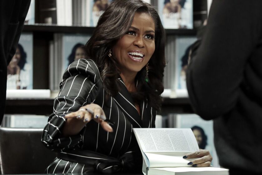 FILE - In this Nov. 30, 2018, file photo, Former First Lady Michelle Obama signs books during an appearance for her book, "Becoming," in New York. Sales for Obamas memoir have topped 3 million and the former first lady is extending her book tour into 2019. Live Nation and Crown Publishing announced Tuesday, Dec. 11, that Obama will have 21 events next year, six of them in Europe. (AP Photo/Richard Drew, File)