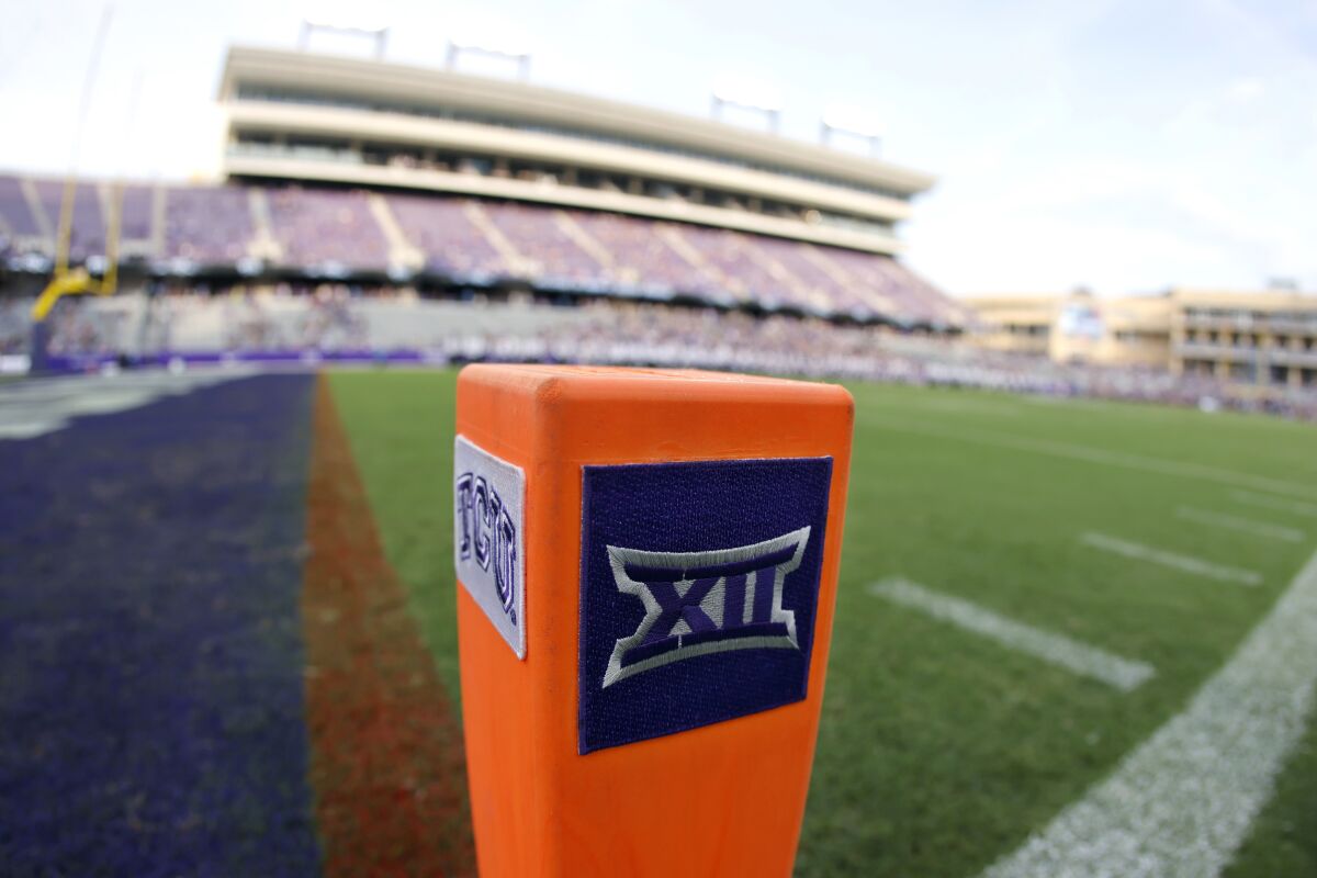 FILE - In this Saturday, Sept. 4, 2021, file photo, a Big 12 Conference logo is displayed on a goal line pylon before Duquesne played TCU in an NCAA college football game, in Fort Worth, Texas. The Big 12 has extended membership invitations to BYU, UCF, Cincinnati and Houston to join the Power Five league. That comes in advance of the league losing Oklahoma and Texas to the Southeastern Conference. (AP Photo/Ron Jenkins, File)
