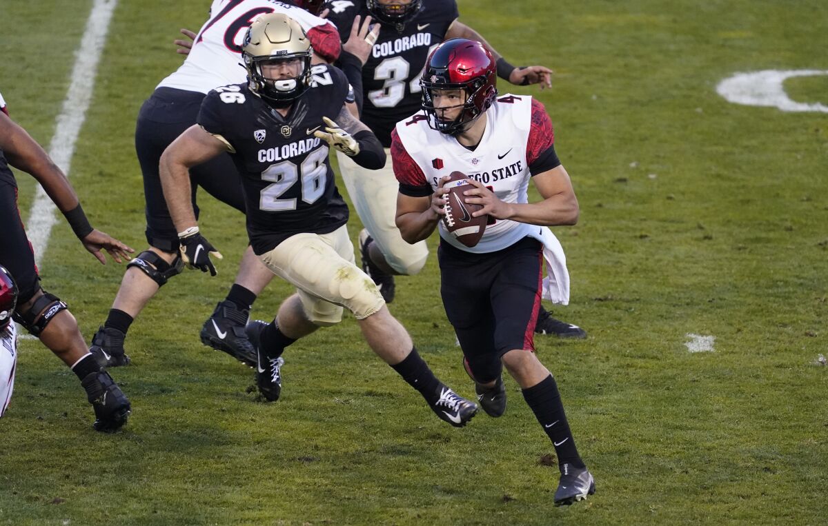 Colorado linebacker Carson Wells, left, pursues San Diego State quarterback Jordon Brookshire, who runs out of the pocket during the first half of an NCAA college football game Saturday, Nov. 28, 2020, in Boulder, Colo. (AP Photo/David Zalubowski)