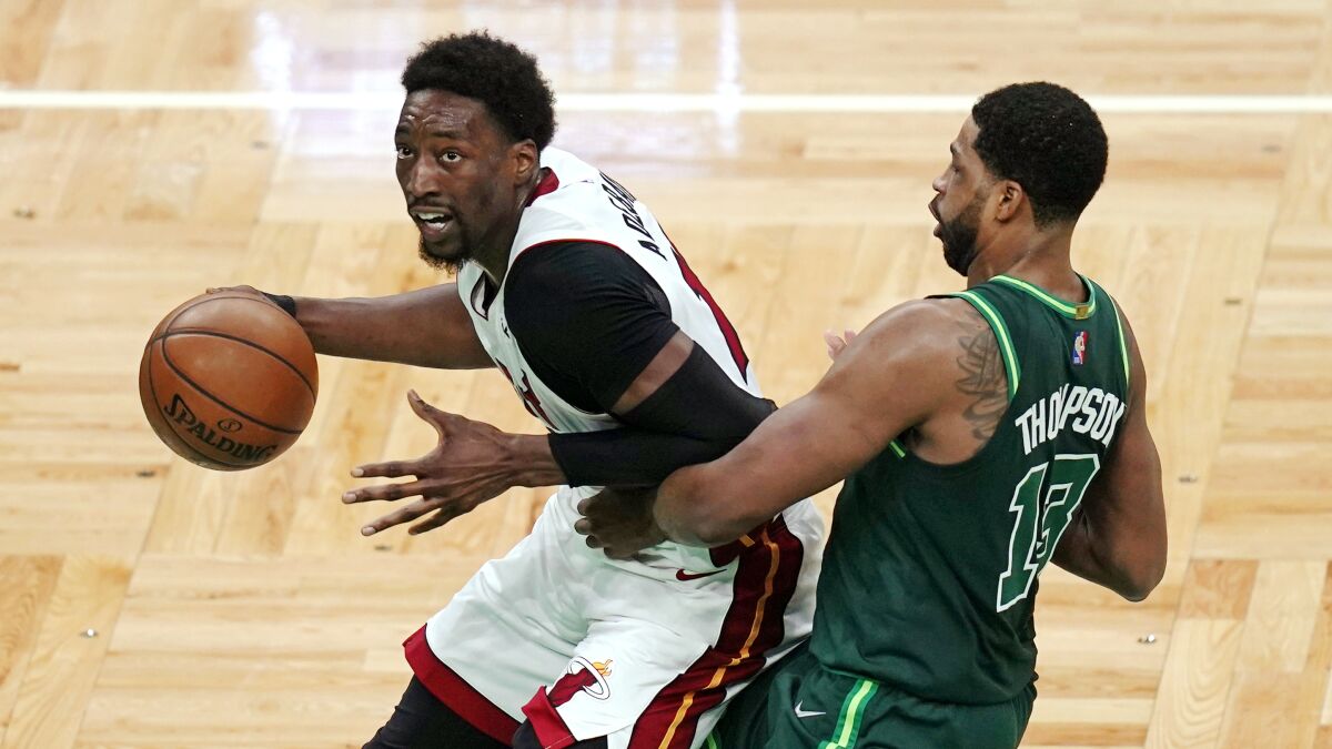 Miami Heat center Bam Adebayo, left, drives to the basket past Boston Celtics center Tristan Thompson during the second half of an NBA basketball game Tuesday, May 11, 2021, in Boston. (AP Photo/Charles Krupa)