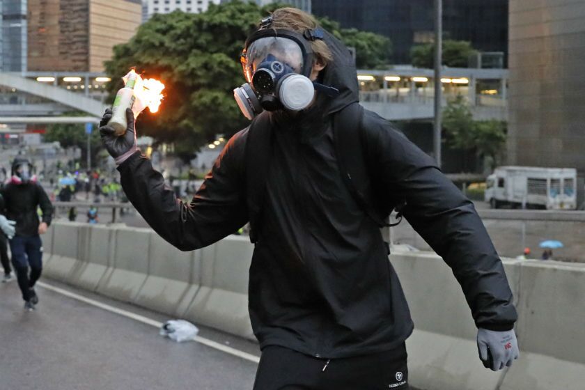 A protester prepares to throw a Molotov cocktail toward police officers during a protest in Hong Kong on Saturday.