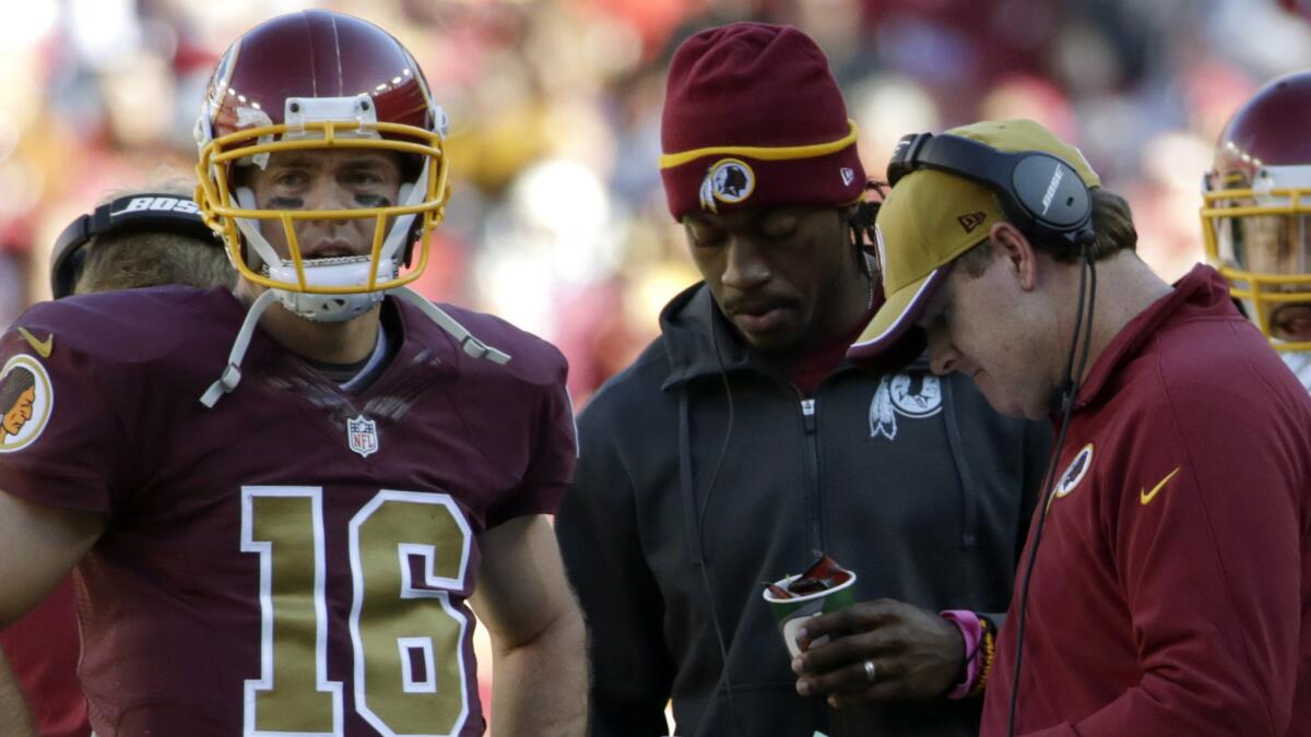 Washington Redskins quarterback Colt McCoy, left, stands with quarterback Robert Griffin III, center, and Coach Jay Gruden during Sunday's win over the Tennessee Titans.
